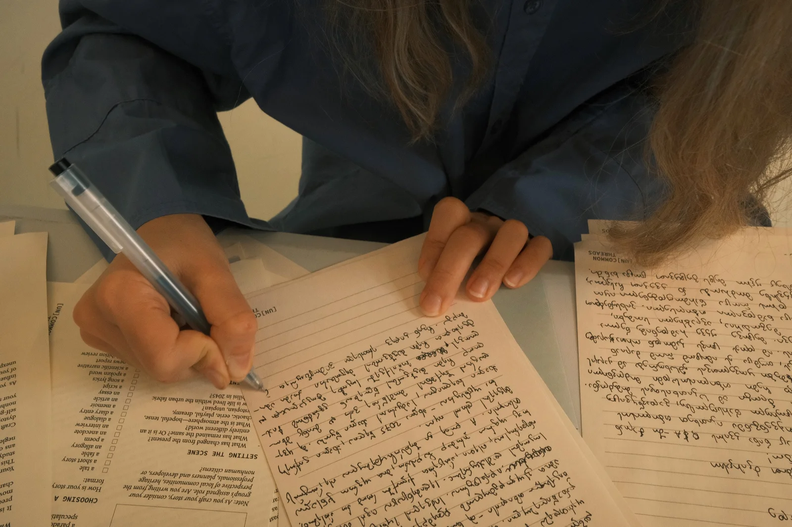 A participant writing in Georgian on a printed [UN]COMMON THREADS worksheet.